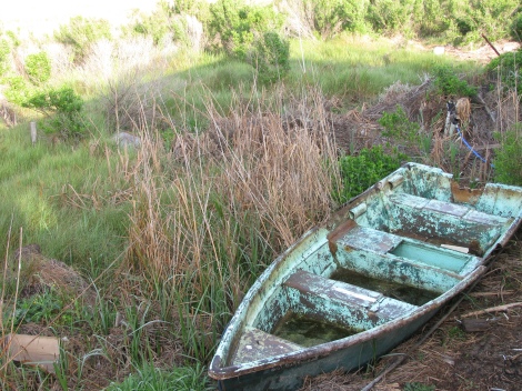 Old boat in the backyard of a house on the Grand Bayou